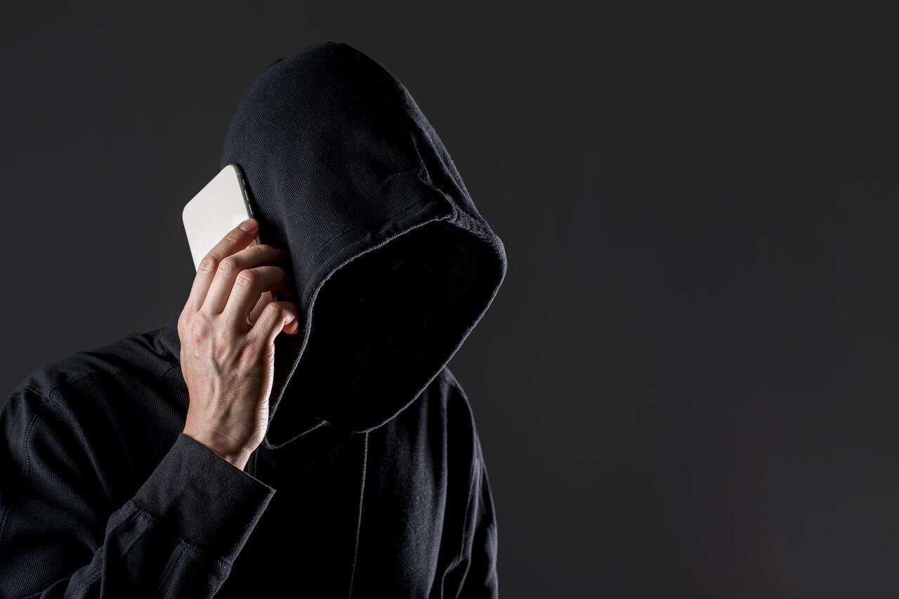 side-view-male-hacker-talking-smartphone-with-copy-space_1_1.jpg